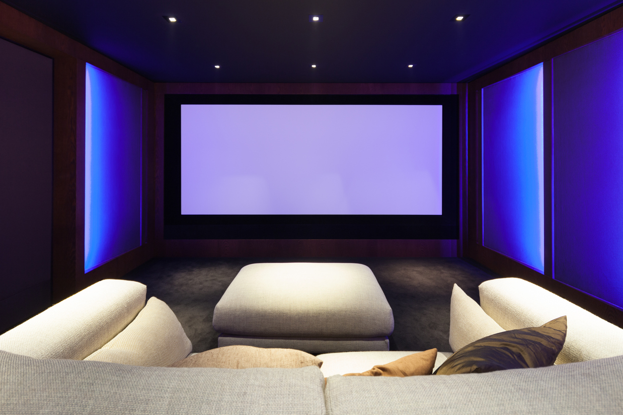 interior of home cinema with projector screen and cream sofa