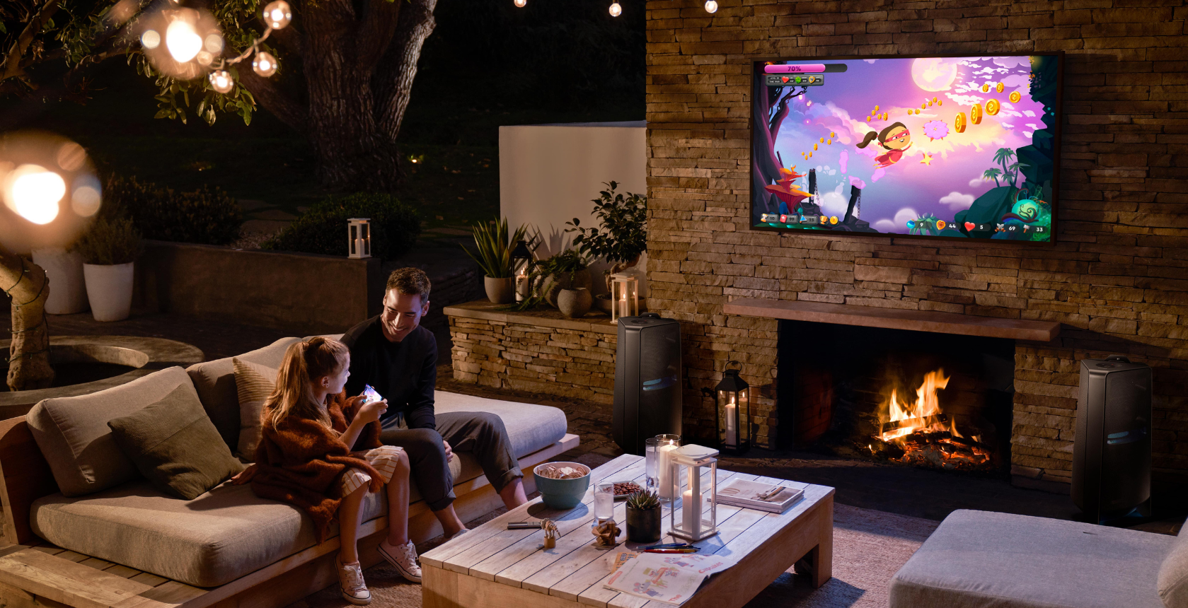 family playing a game and laughing in outdoor entertainment area at night