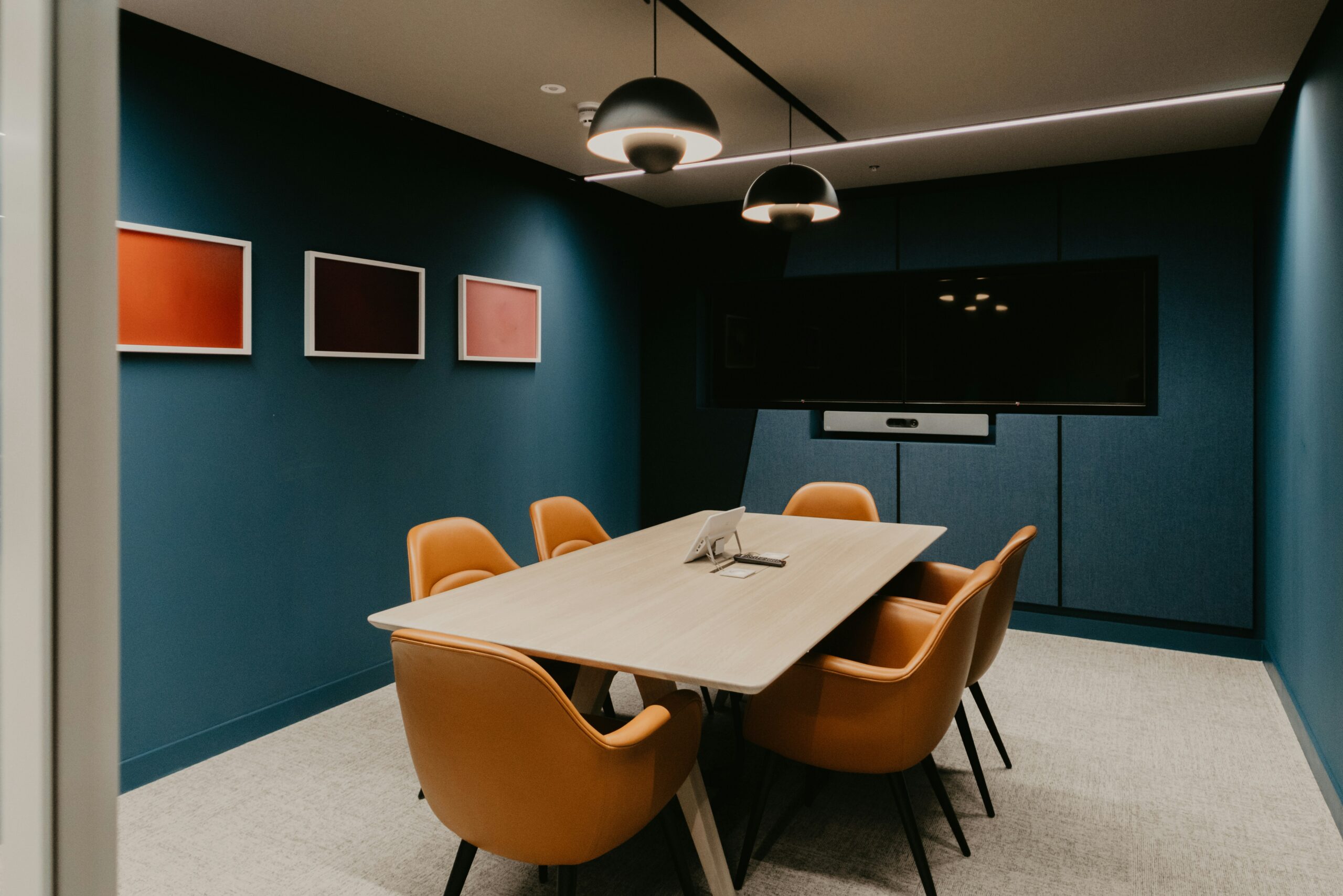 orange and blue meeting room with office lighting, screen and speakers